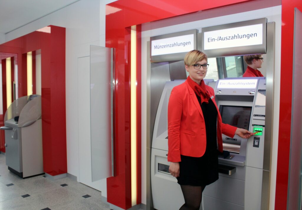 Sparkassenmitarbeiterin Sophia Hesse präsentiert die neuen Selbstbedienungsgeräte.