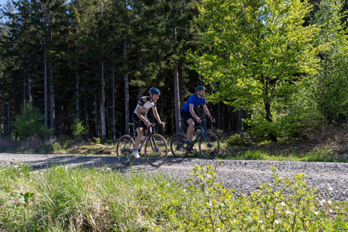 Zwei Radfahrer erkunden die Bike Arena Sauerland auf ihren Gravelbikes. Die neue Trendsportart eignet sich wunderbar für Touren in der grünen Freizeitregion.