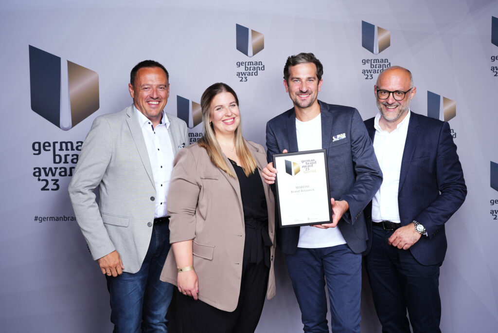 von links nach rechts: Georg Voss, MAREDO, Preisverleiherin von German Brand Award, Sebastian Uting, VIEREINHALB und Marcus Voeste, MAREDO