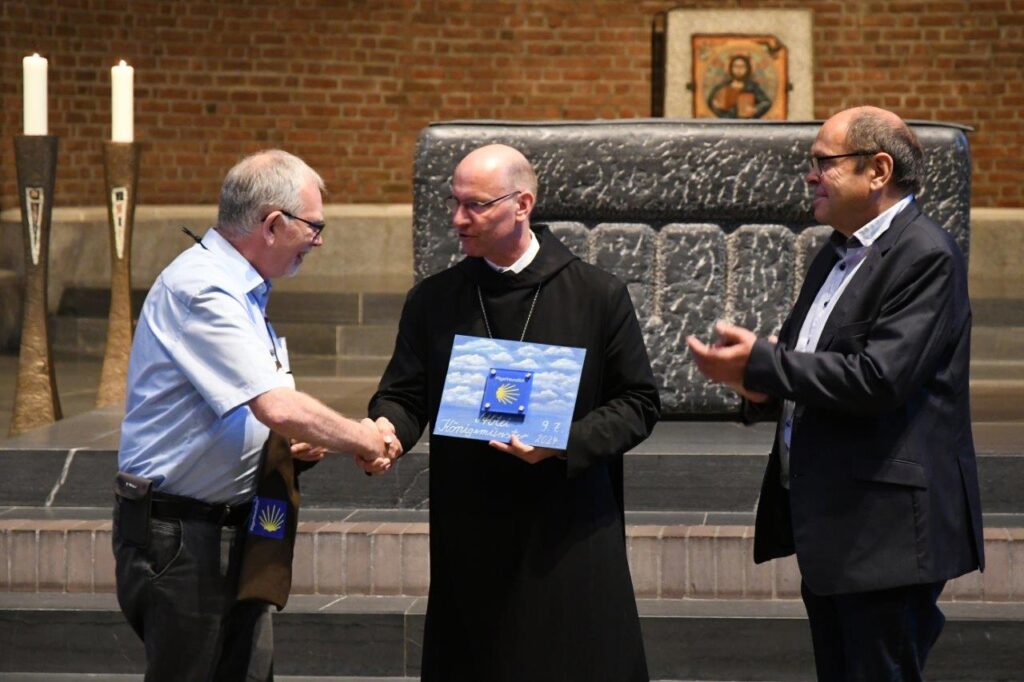Abt Cosmas erhält von Heino v. Groote (Jakobusfreunde Paderborn, li.) und Michael Kronauge (Vorsitzender Sauerländer Heimatbund) die Plakette zur Zertifizierung als Pilgerherberge